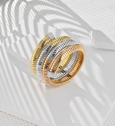 Three-row Tubogas wrap bracelet in yellow, white and rose gold with diamond pavé triangular ends