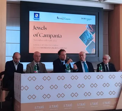 The opening conference: five speakers at the table beneath the Jewels of Campania screen.