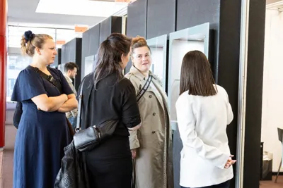 Four participants talking near the showcases.