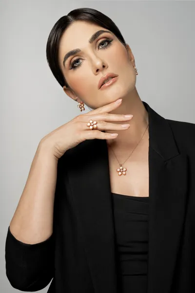 Model wearing Melany Collection earrings, necklace and ring in 9kt gold with diamonds and petal cameos on cornelian shell