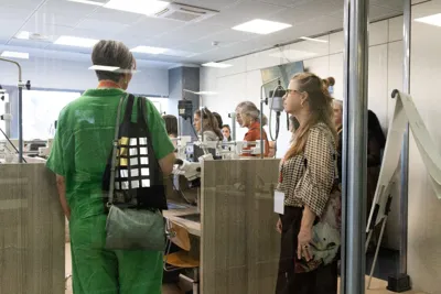 Visitors watching goldsmiths at work in a workshop.