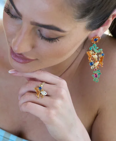 Model wearing fish-shaped earrings and ring in 925 silver with semi-precious stones