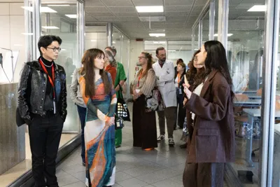Buyers on a guided tour, listening in a bright corridor.