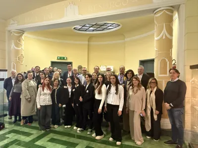 Group photograph of the delegation in a hall with a decorated ceiling.
