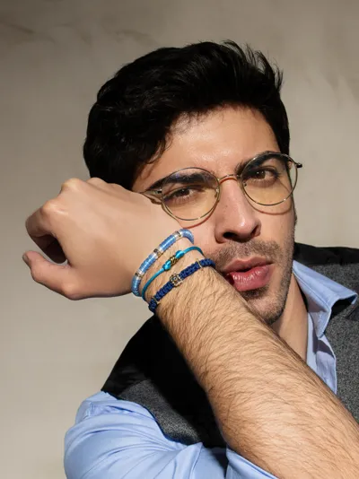 Man wearing bracelets in gold and sapphires, marine cord and crystal