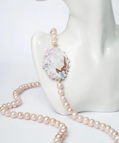 Cultured pearl necklace with an enamelled cameo, on a white bust