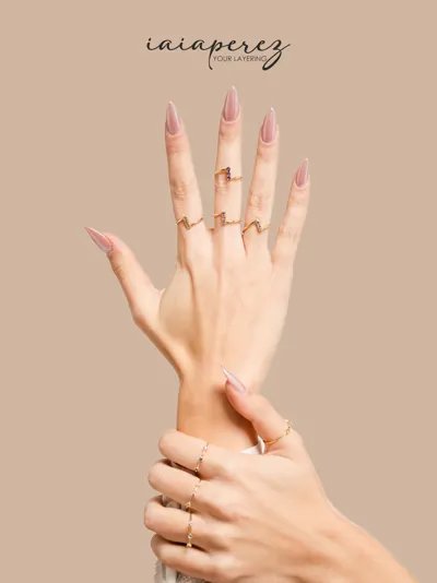 Hand wearing rings with peridot, amethyst, sky blue topaz and pink sapphire in 9kt gold, iaiaperez