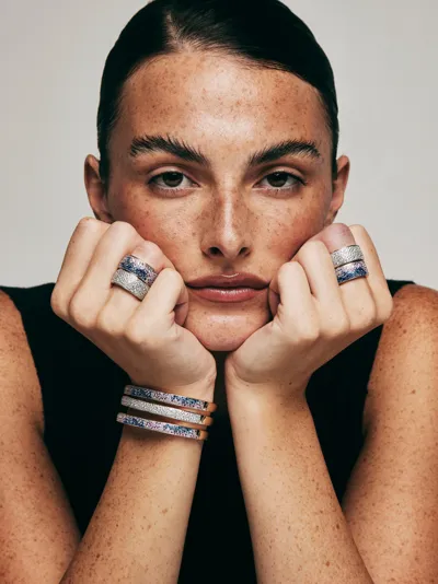 Sogni – Model wearing Infiniti Collection band rings and stacked bangles with blue and white stones, silver with 18-karat gold plating