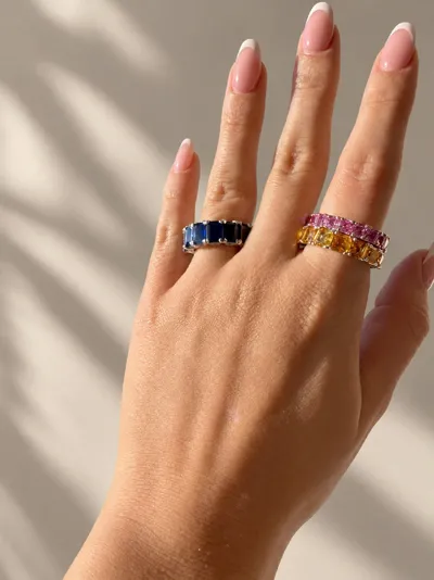 Hand wearing 18Kt white gold rings with blue, yellow and pink sapphires