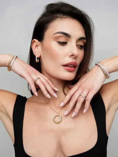 Sogni – Model wearing Icona Collection twisted bangles, rings, hoop earrings and a circle pendant, silver with 18-karat gold plating