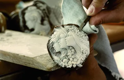 Master engraver hand-carving a shell cameo with a woman's profile