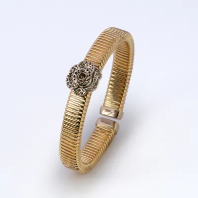 Yellow gold tubogas cuff bracelet with a white gold rose mounting, stones not yet set