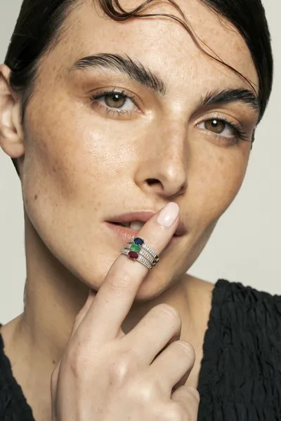 Model wearing 18-karat gold rings with natural diamonds and oval sapphires, Ibiza collection