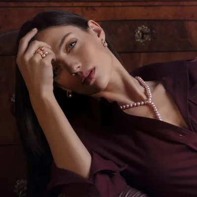 Model wearing a necklace, earrings and ring in 18-karat rose gold with pink freshwater pearls and diamonds