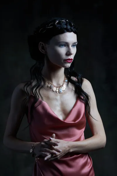 Model wearing a silver necklace and bracelet with carved shell and silver medals, Sacred collection
