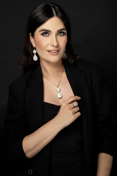 Model wearing Capri Collection earrings, necklace and ring in 9kt gold with diamonds and flower cameos on mother of pearl