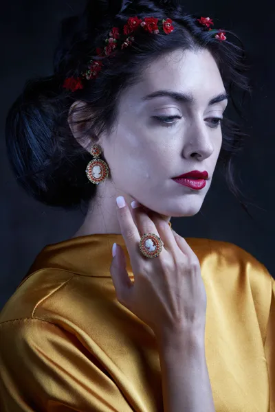 Model wearing silver and coral earrings and ring with hand-carved shell cameos, Victoria collection