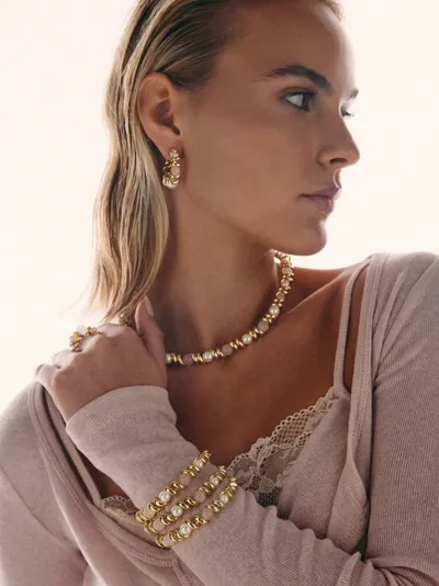 Sogni – Model wearing an Armonia Collection necklace, stacked bracelets and earrings with pearls, brass-based alloy with 18-karat gold plating