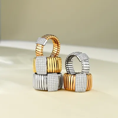 Four Tubogas rings in yellow, white and rose gold with diamond pavé plates, stacked