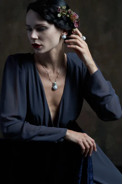 Model wearing earrings and a pendant in enamelled silver with hand-carved shell cameos, Pompea collection