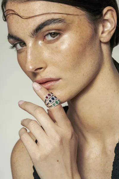 Model wearing 18-karat gold trilogy rings with natural diamonds, rubies and sapphires, Valencia collection