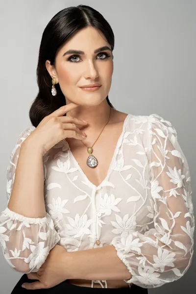 Model wearing a Clarissa Collection necklace in gold-plated sterling silver with cubic zirconia and a flower cameo on sardonyx shell