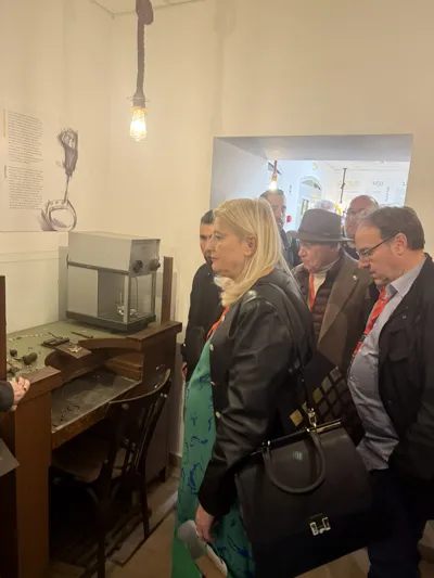 Visitors in a workshop, next to a goldsmith's bench.