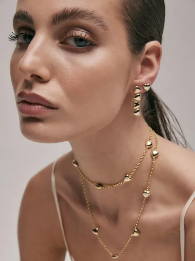Sogni – Model wearing Romantici Collection layered necklaces with heart charms and heart drop earrings, silver with 18-karat gold plating