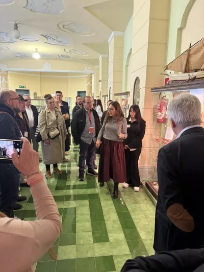 Visitors walking through a hall with a green patterned floor.