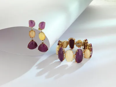 Earrings and bracelet with purple and milky white stones set in gold