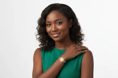 Woman in a green top wearing a gold bracelet with a shell cameo and malachite